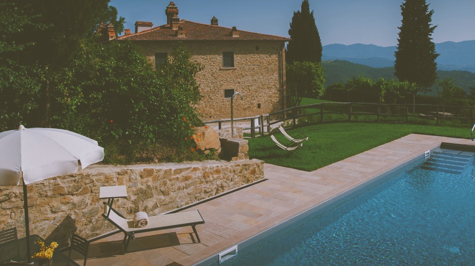 White umbrella outside a villa by the pool