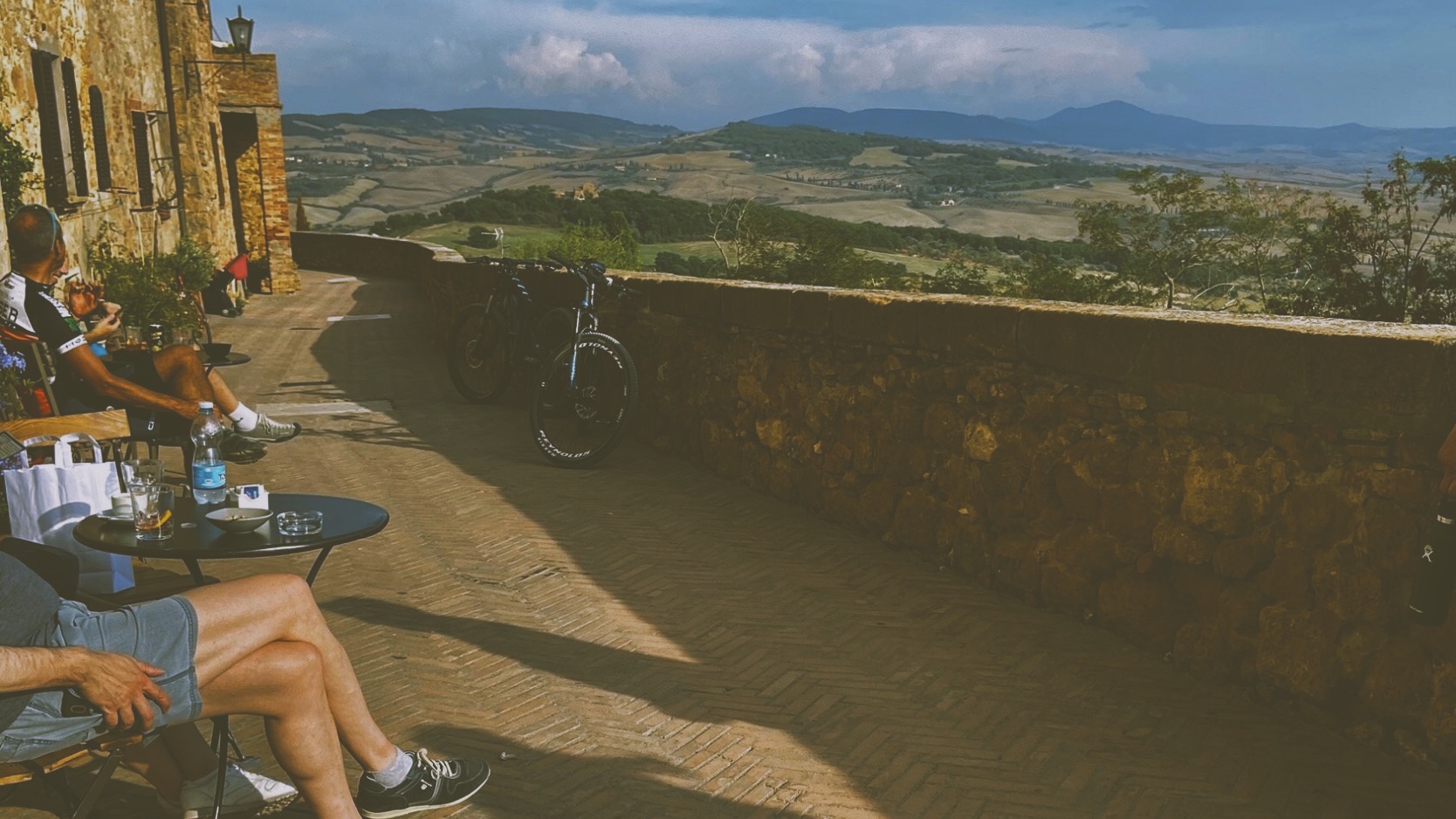 People drinking while watching the Italian countryside.